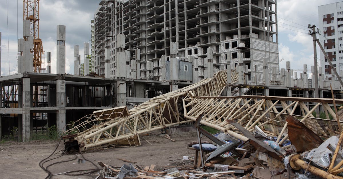 An urban construction site featuring a collapsed crane and unfinished buildings under cloudy skies.